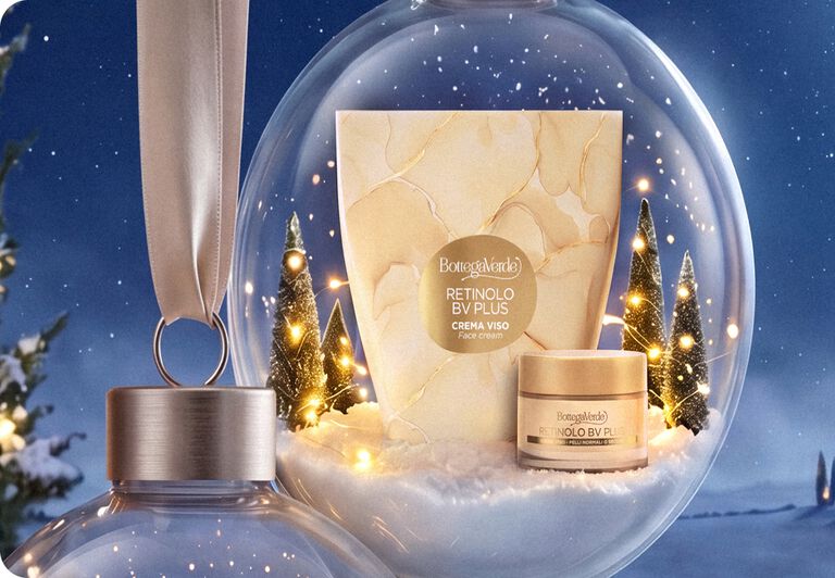 Confezione e crema viso Retinolo BV Plus Bottega Verde dentro una sfera di neve natalizia
