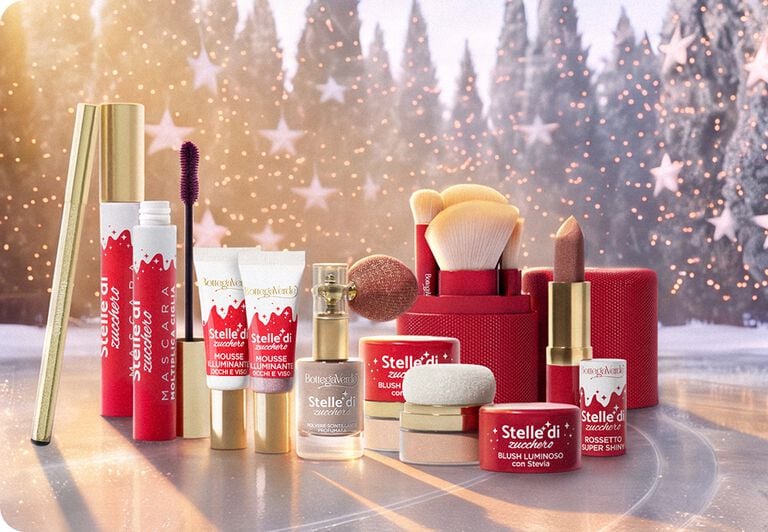 Prodotti make-up Stelle di Zucchero Bottega Verde con rossetti e pennelli su sfondo natalizio